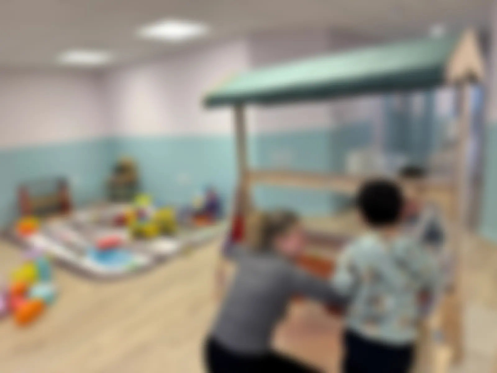 A practitioner supporting a child at the water-play table in the free-flow play zone