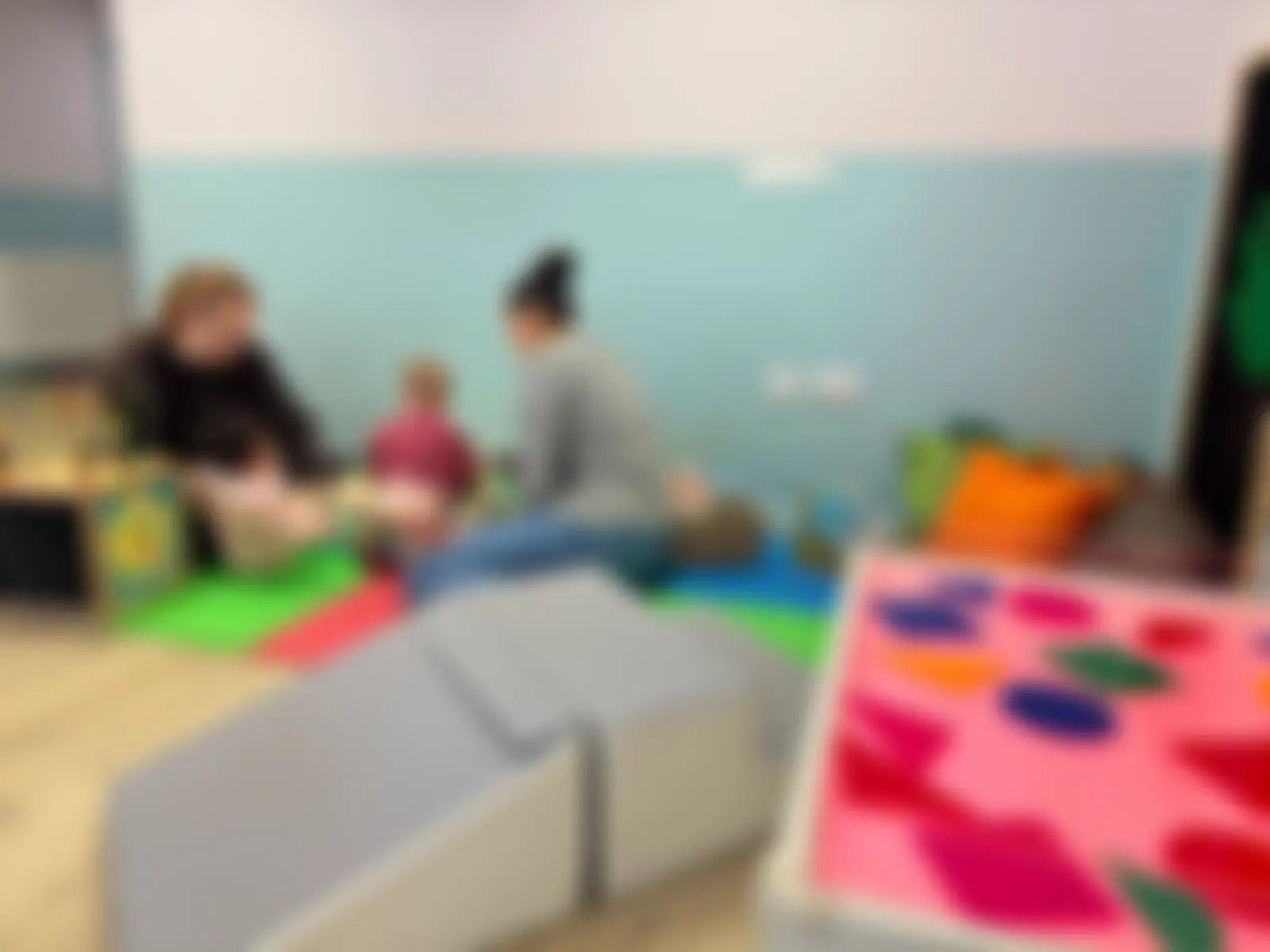 Small group learning zone with practitioners on the floor with children