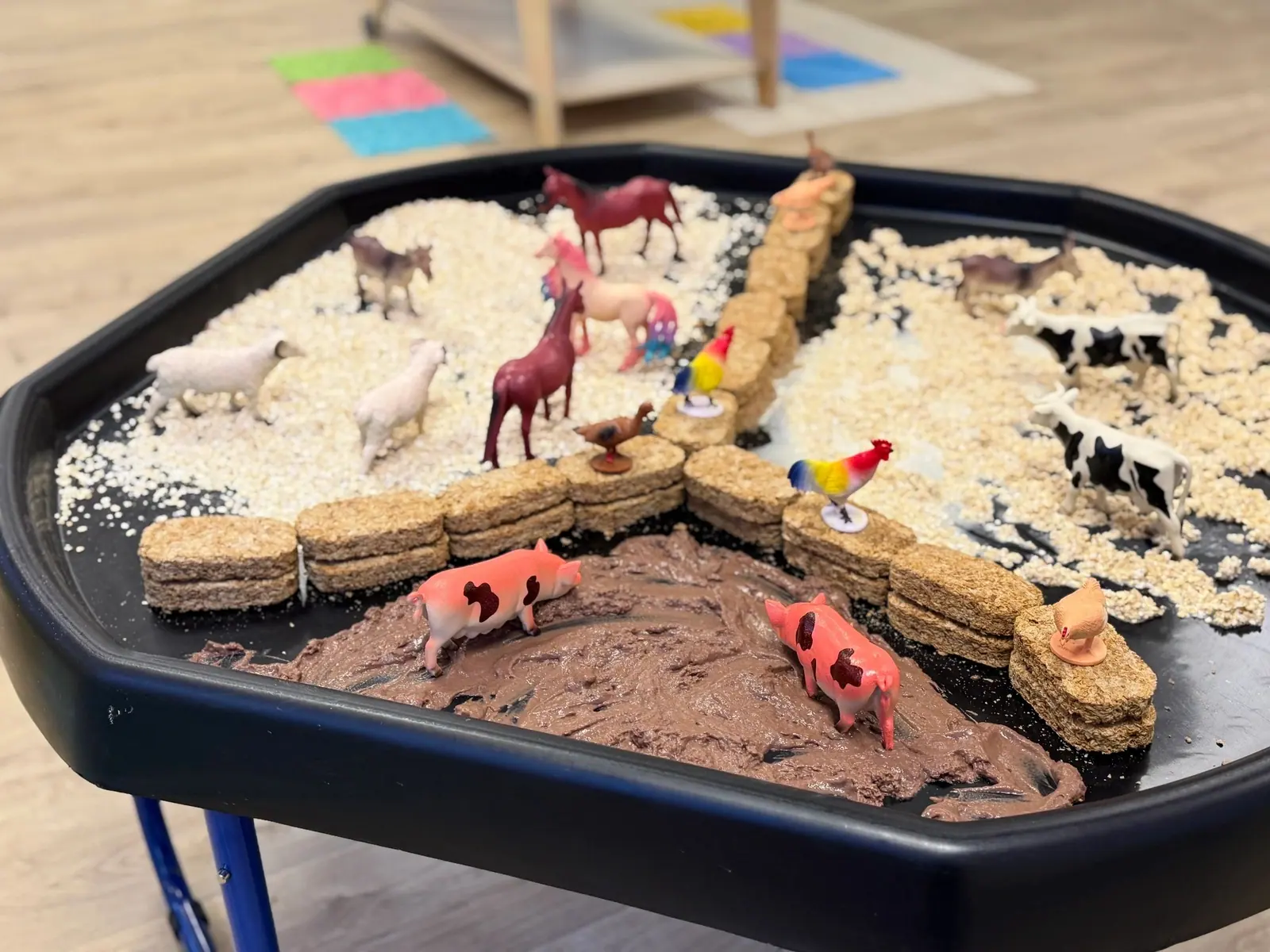 Farm small-world tuff tray with oats, soil-coloured playdough and animal figures